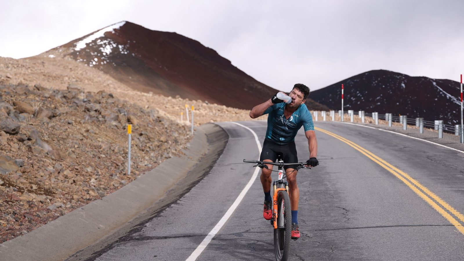 Cycliste buvant sur une route de montagne pendant un effort d'endurance