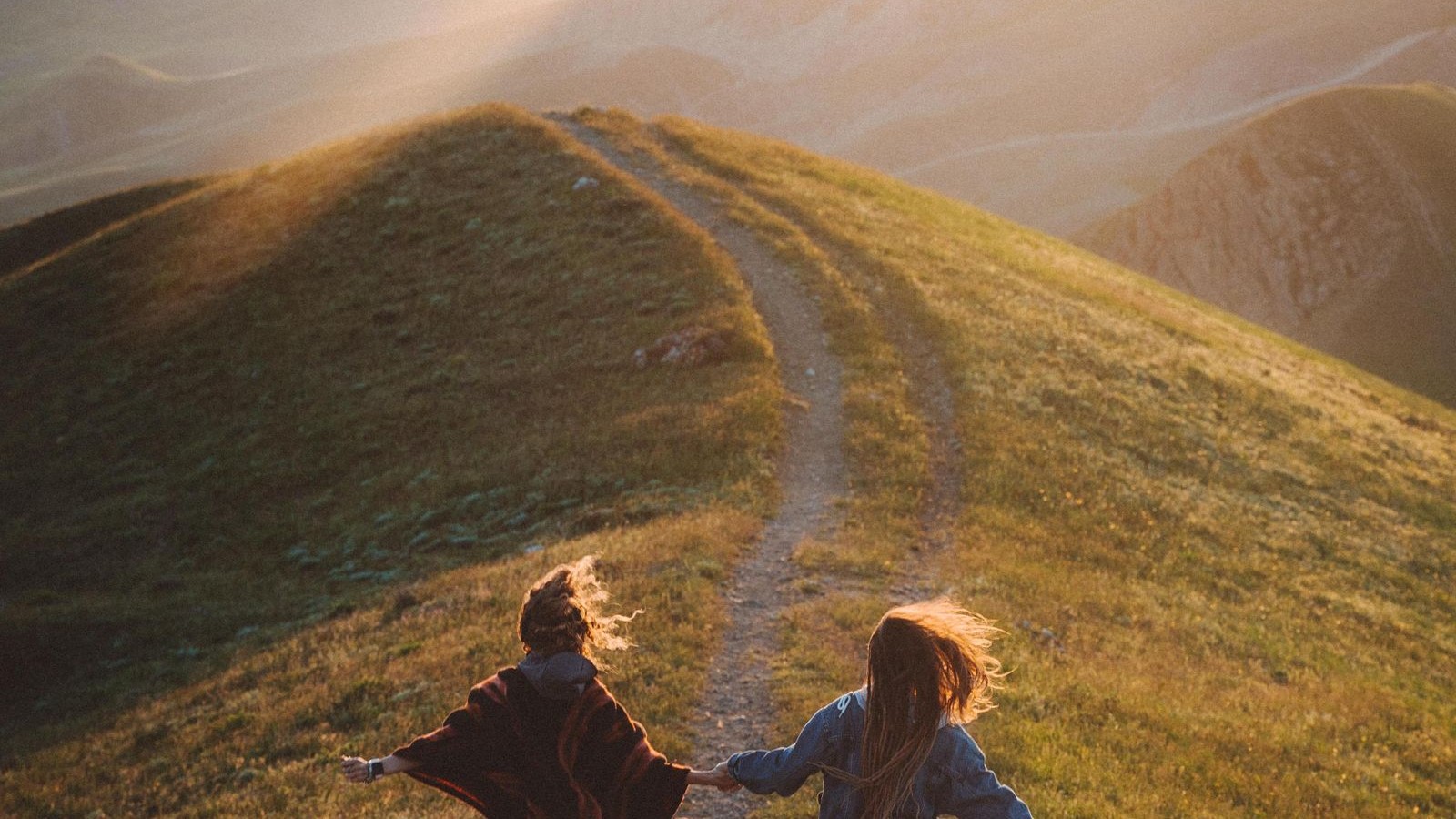 Deux coureuses sur un sentier de montagne au coucher du soleil