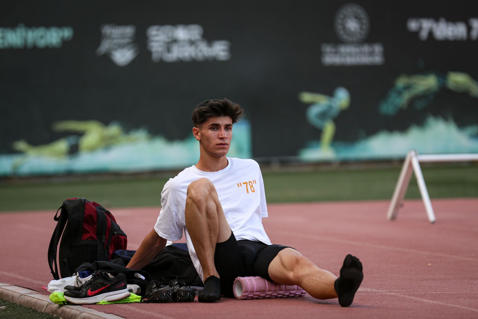 Sportif utilisant un rouleau de massage au bord d'une piste