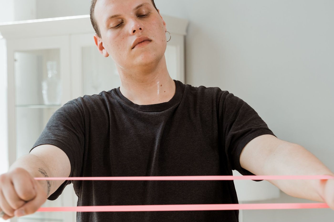 Sportif réalisant un exercice de renforcement avec un élastique à domicile