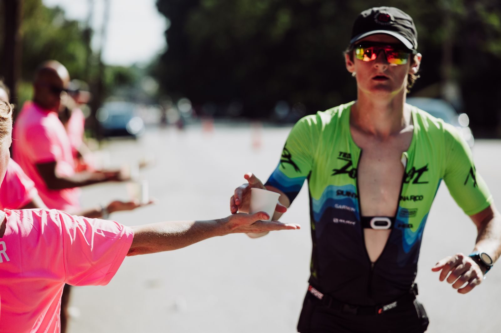 Coureur recevant de l'eau d'un bénévole à un ravitaillement de marathon