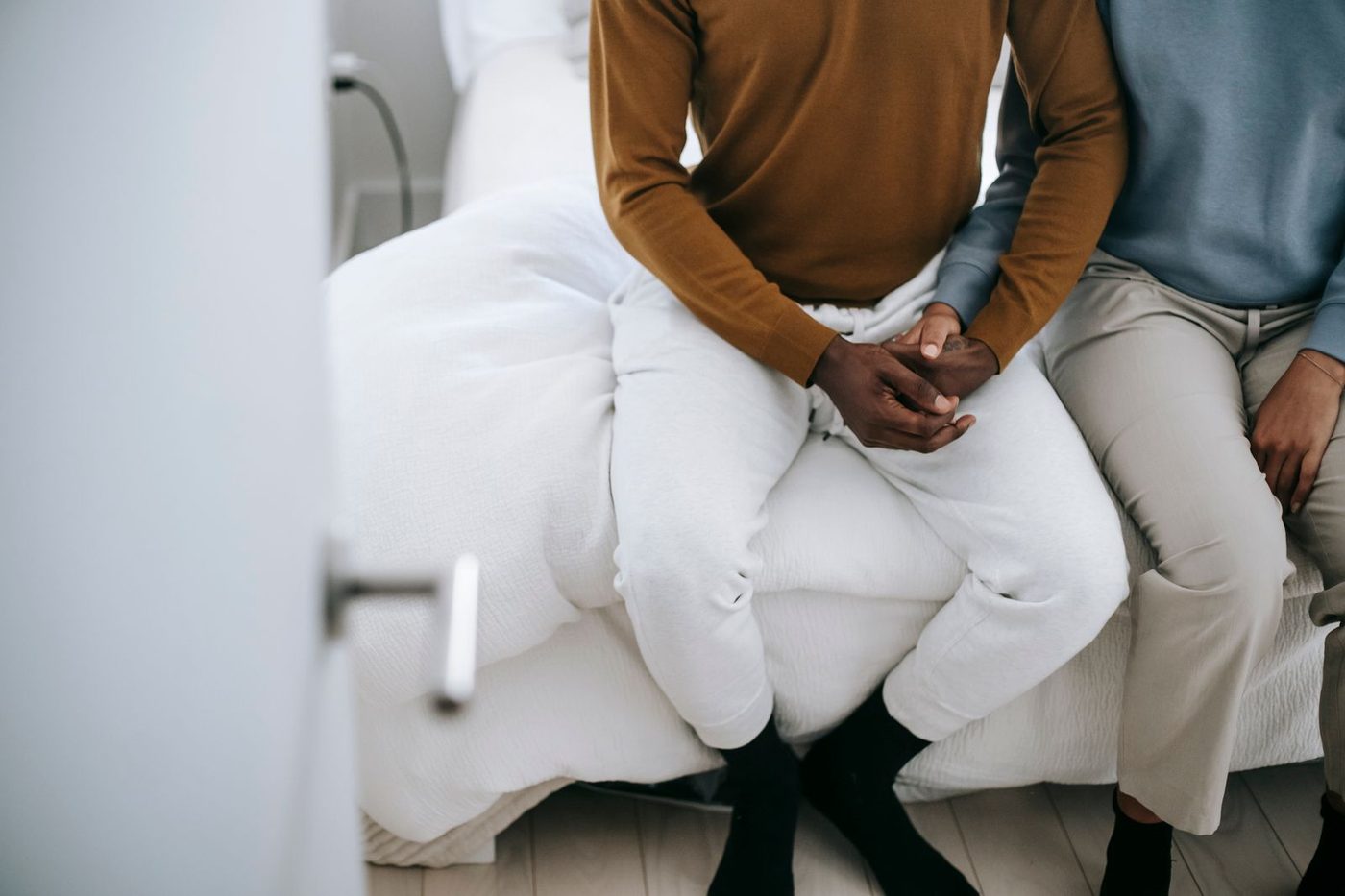 Couple anonyme se tenant la main dans une chambre