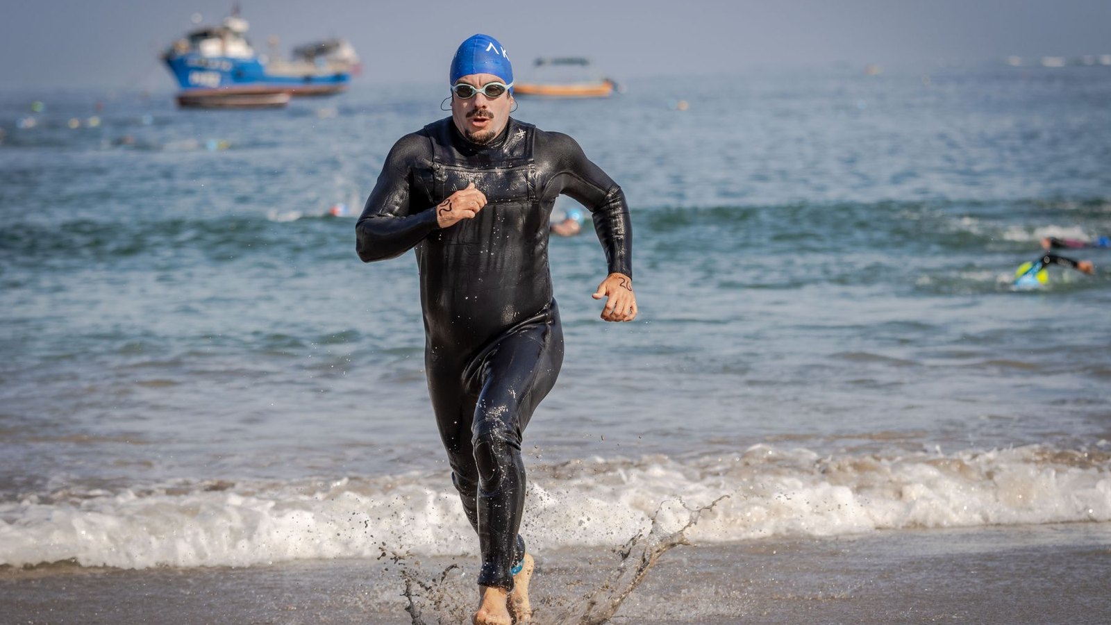 Triathlète en combinaison sortant de la mer avant la transition de la natation vers le vélo